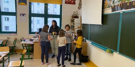 Powiększ grafikę: Dwie nauczycielki i trzy dziewczynki - uczennice stoją w sali lekcyjnej i rozmawiają ze sobą
