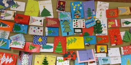 Powiększ grafikę: Kartki świąteczne dzieci leżące na stole.