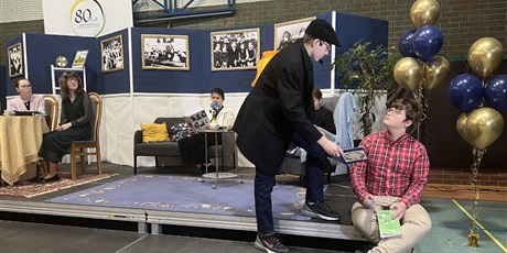 Powiększ grafikę: Na scenie w sali gimnastycznej uczniowie i uczennice grają swoje role w przedstawieniu