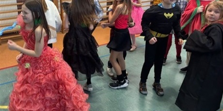 Powiększ grafikę: dziewczynki i chłopcy z klas młodszych tańczą na sali gimnastycznej w strojach karnawałowych