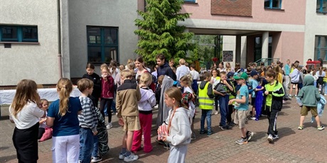 Powiększ grafikę: Dzień Dziecka, dzieci na dziedzińcu szkoły stoją w kolejce po watę cukrową i popcorn