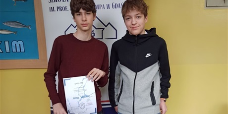 Powiększ grafikę: 2 chłopców pozuje do zdjęcia. Jeden z nich trzyma dyplom laureata.