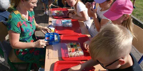 Powiększ grafikę: dzieci tworzą na stanowisku kolorowe bransoletki