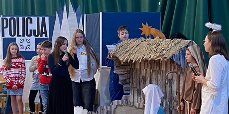 Powiększ grafikę:  Na scenie aktorzy, w tle komisariat, stajenka, najbliżej anioł 