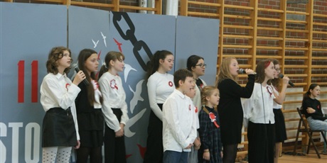 Powiększ grafikę: Dziewczynki z chóru szkolnego występują na apelu z okazji 11 listopada