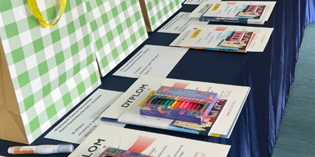 Powiększ grafikę: na stole leżą dyplomy i nagrody dla uczestników konkursu