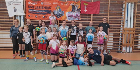 Powiększ grafikę: Rodzice z dziećmi pozują do zdjęcia w sali gimnastycznej pod drabinkami