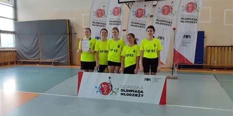 Powiększ grafikę: Pięć dziewczynek stojących w sali gimnastycznej po zwycięskim meczu